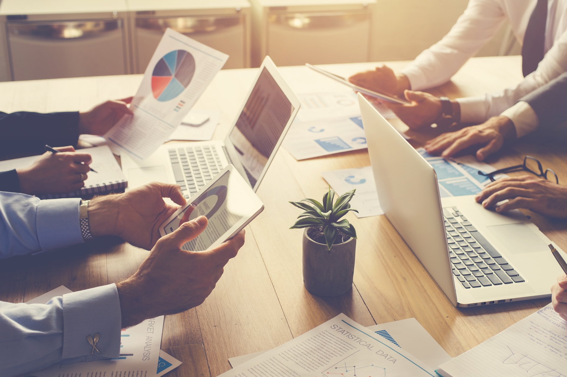 Gruppe von Menschen an einem Tisch arbeiten mit mobilen Apps